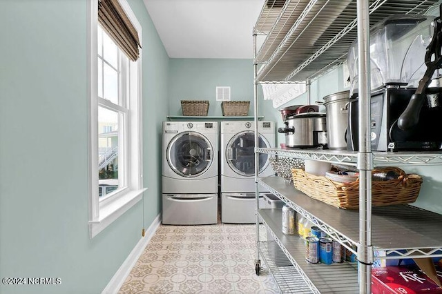 laundry area with baseboards, washer and clothes dryer, and tile patterned floors