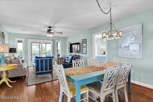 dining room with ceiling fan with notable chandelier, baseboards, and wood finished floors