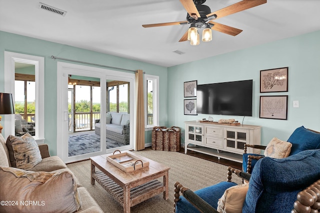 living room with ceiling fan, wood finished floors, and visible vents