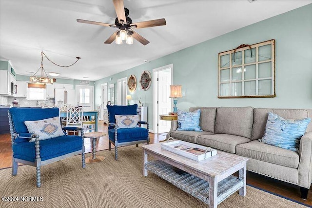 living room featuring hardwood / wood-style floors and ceiling fan with notable chandelier