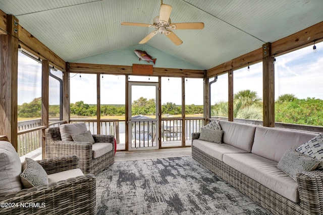 sunroom / solarium with ceiling fan, plenty of natural light, a water view, and lofted ceiling