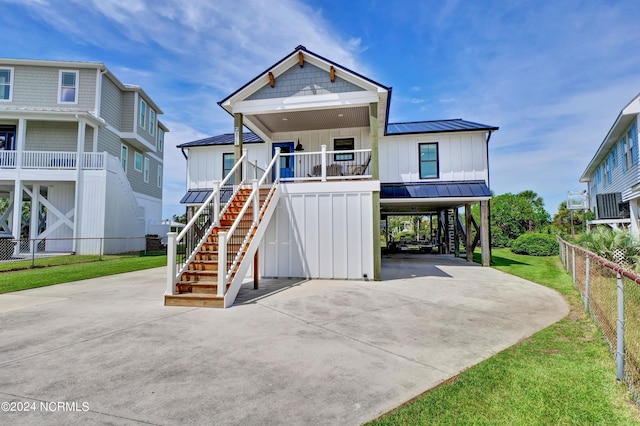 view of front of property featuring covered porch, a front yard, and a carport