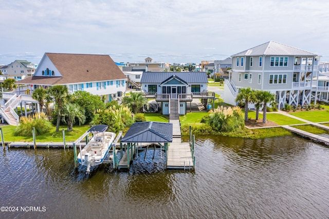 view of dock with a water view, boat lift, a residential view, and a lawn