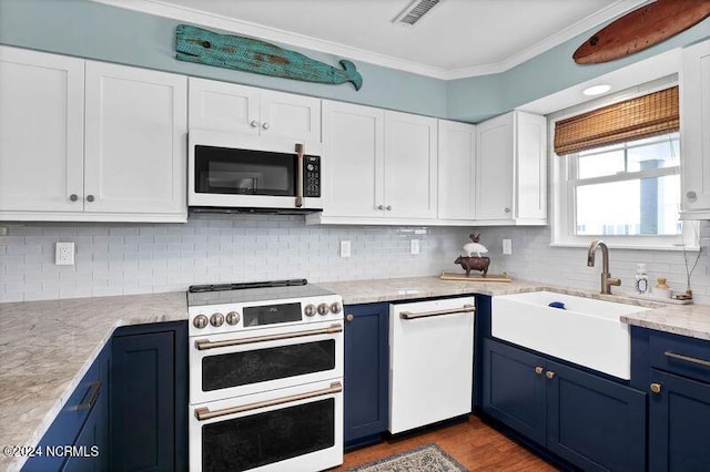 kitchen featuring visible vents, ornamental molding, a sink, blue cabinets, and double oven range