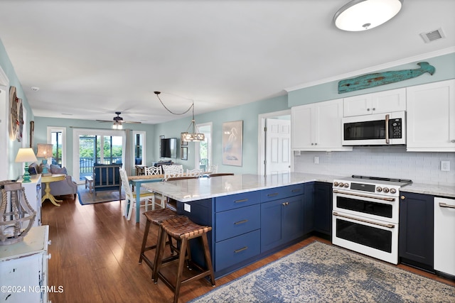 kitchen with visible vents, white cabinets, light stone countertops, white appliances, and a peninsula