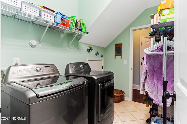 washroom with washing machine and clothes dryer and light tile patterned floors