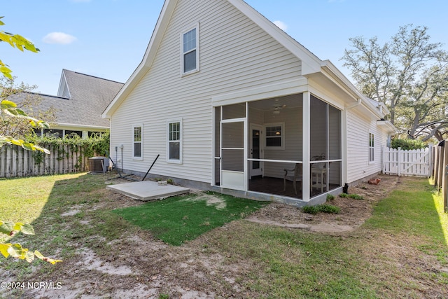 back of house featuring a sunroom, central air condition unit, and a lawn