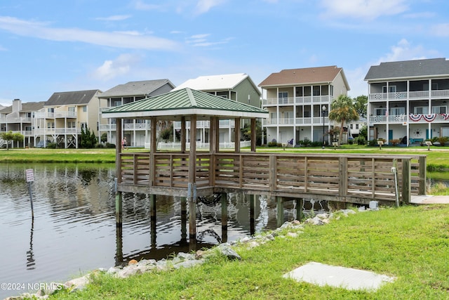 view of dock featuring a gazebo, a lawn, and a water view