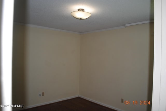 empty room featuring hardwood / wood-style flooring, ornamental molding, and a textured ceiling