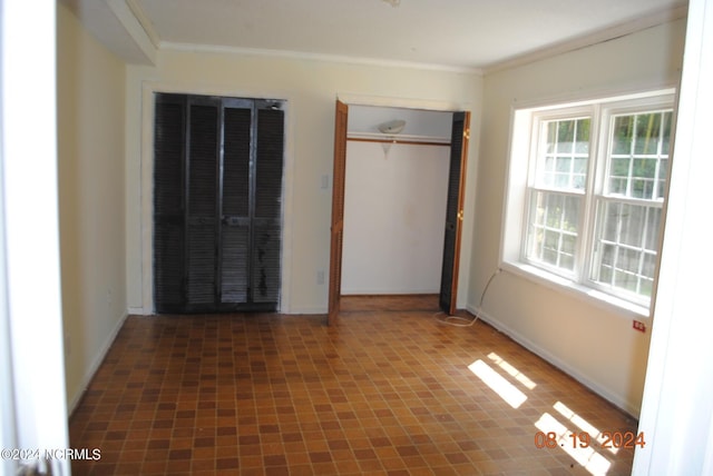 unfurnished bedroom with baseboards and ornamental molding