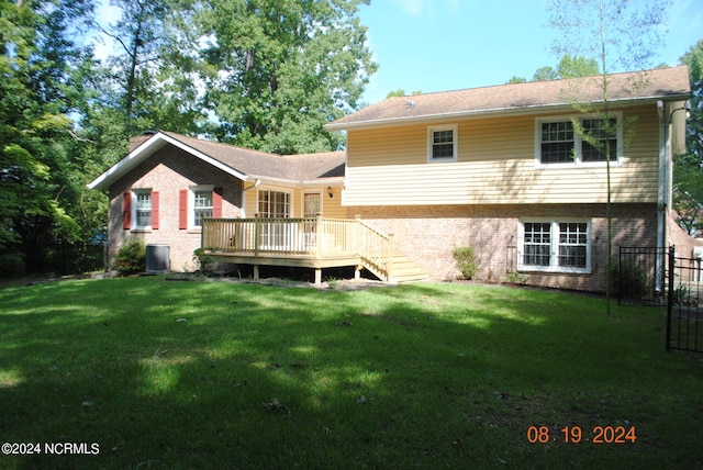 rear view of property featuring a wooden deck, cooling unit, and a yard