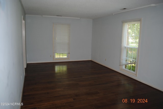 spare room with hardwood / wood-style floors and plenty of natural light