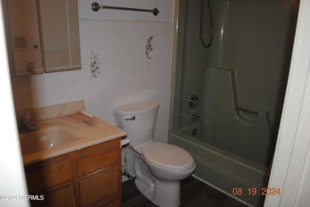 bathroom with shower / tub combination, toilet, tile walls, and vanity