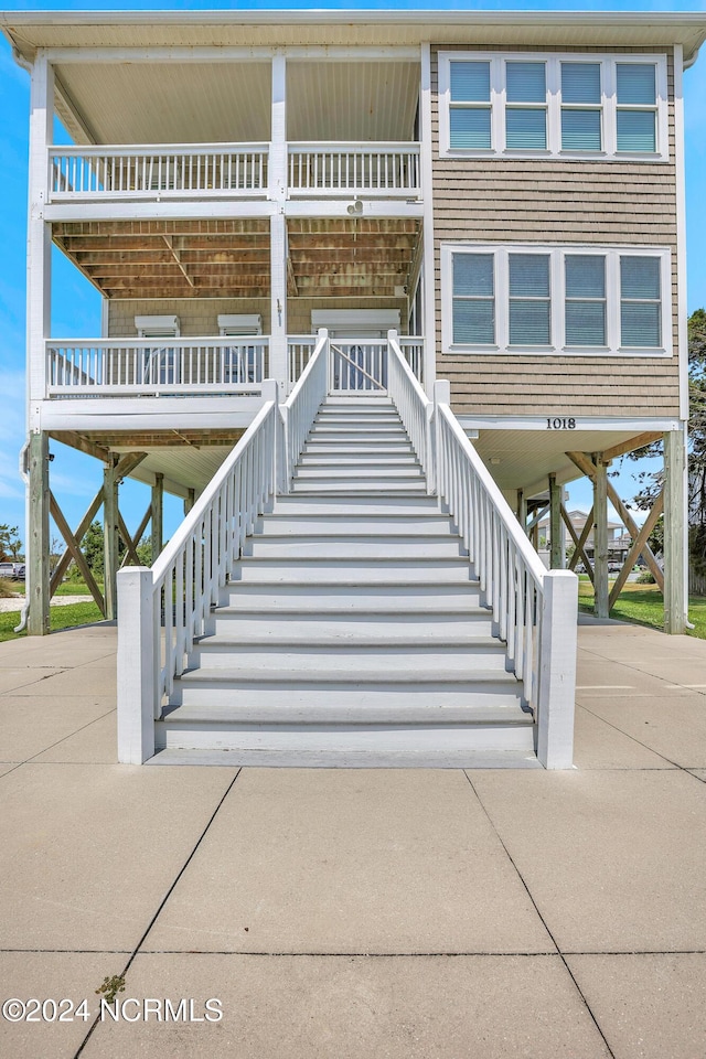 view of building exterior with stairs, a carport, and concrete driveway