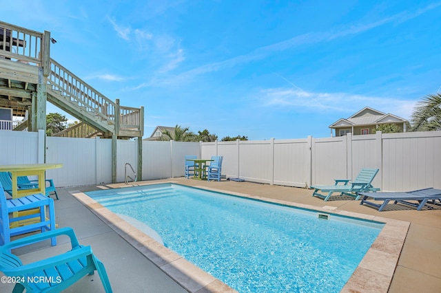 view of pool featuring a patio, stairway, a fenced backyard, and a fenced in pool