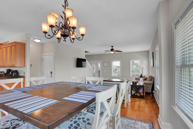 dining room featuring light wood finished floors and ceiling fan with notable chandelier