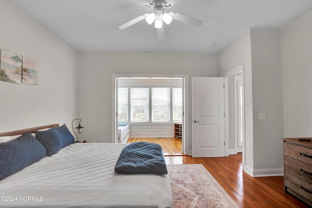 bedroom with a ceiling fan, baseboards, and wood finished floors