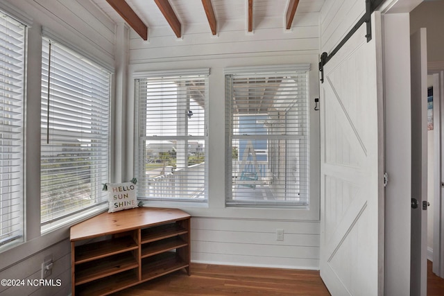 sunroom featuring a barn door and beamed ceiling