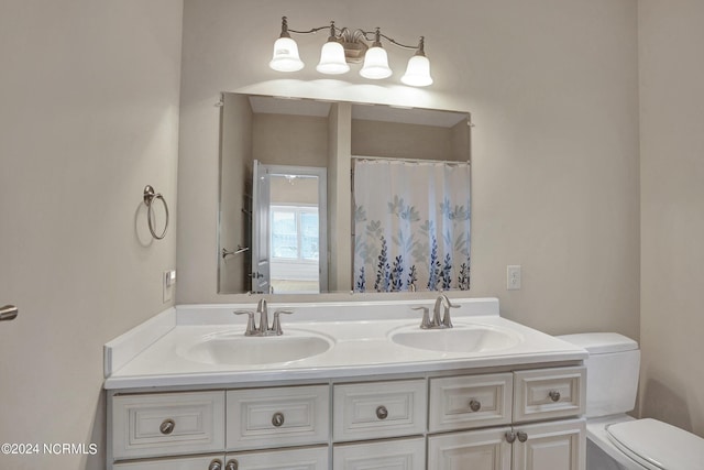 full bathroom with double vanity, a shower with shower curtain, a sink, and toilet