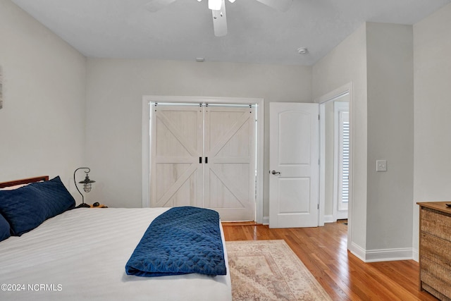 bedroom with a ceiling fan, baseboards, and light wood finished floors