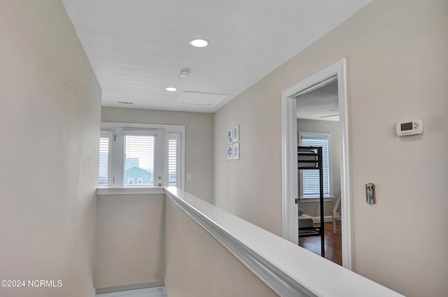 hallway featuring recessed lighting, wood finished floors, an upstairs landing, baseboards, and attic access