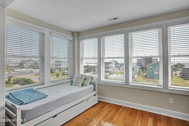 bedroom with light wood-type flooring, visible vents, and baseboards