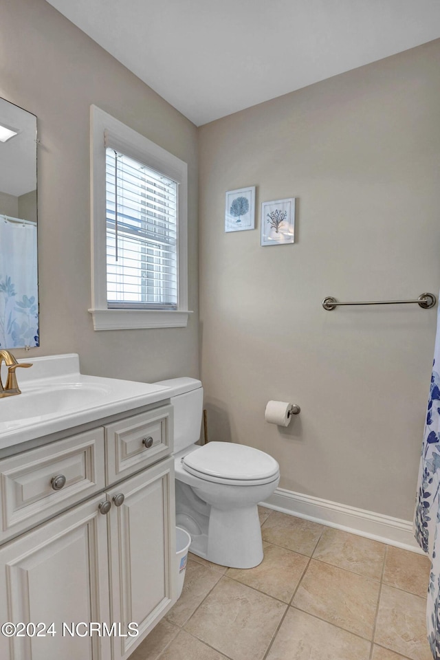 full bath featuring toilet, tile patterned flooring, baseboards, and vanity