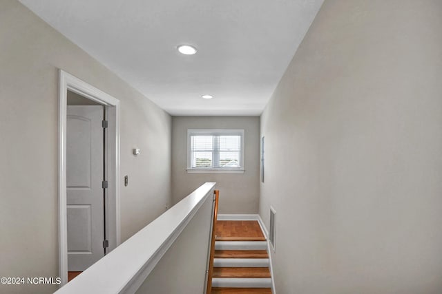 stairway with baseboards, visible vents, wood finished floors, and recessed lighting