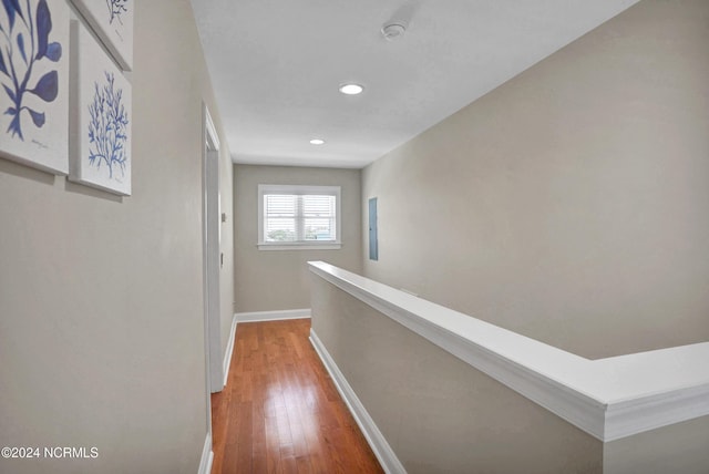 hallway with an upstairs landing, recessed lighting, baseboards, and wood finished floors