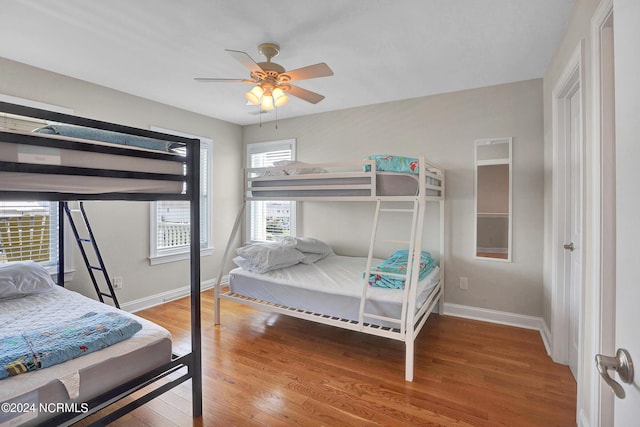 bedroom featuring ceiling fan, baseboards, and wood finished floors