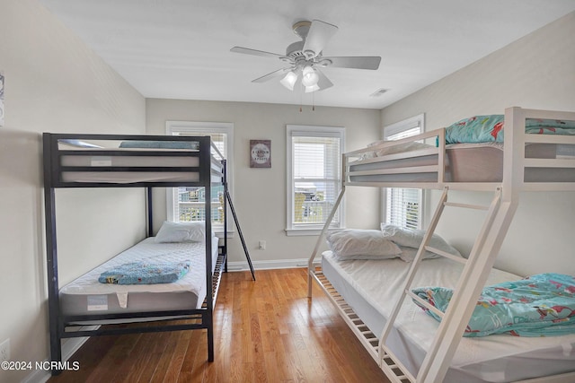 bedroom featuring visible vents, baseboards, and wood finished floors