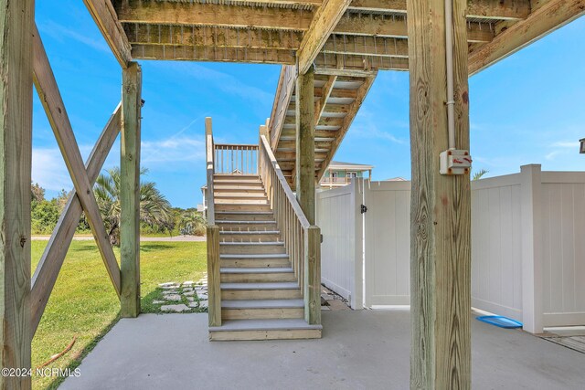 view of patio with fence and stairway