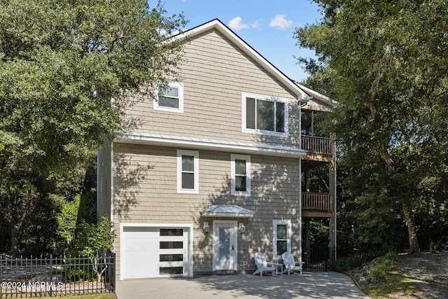 view of front of property featuring a balcony and a garage