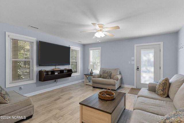 living room with ceiling fan, a wealth of natural light, and light hardwood / wood-style flooring