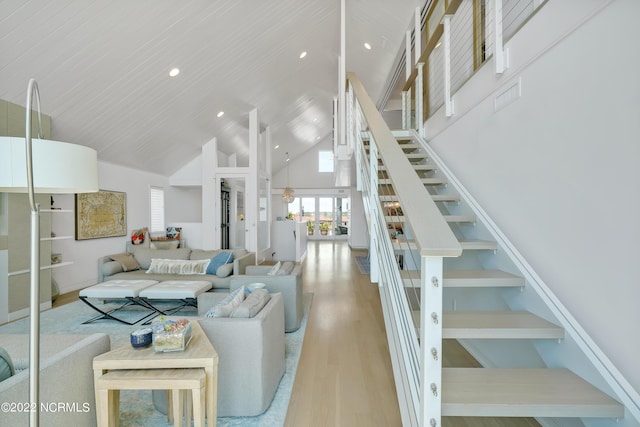 living area with recessed lighting, stairway, high vaulted ceiling, and wood finished floors