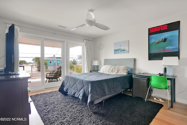 bedroom with visible vents, access to outside, wood finished floors, baseboards, and ceiling fan