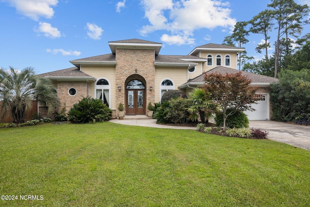 view of front of property featuring a garage, a front lawn, and french doors