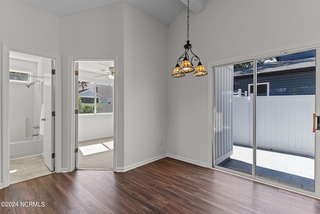 unfurnished dining area with ceiling fan with notable chandelier and hardwood / wood-style floors