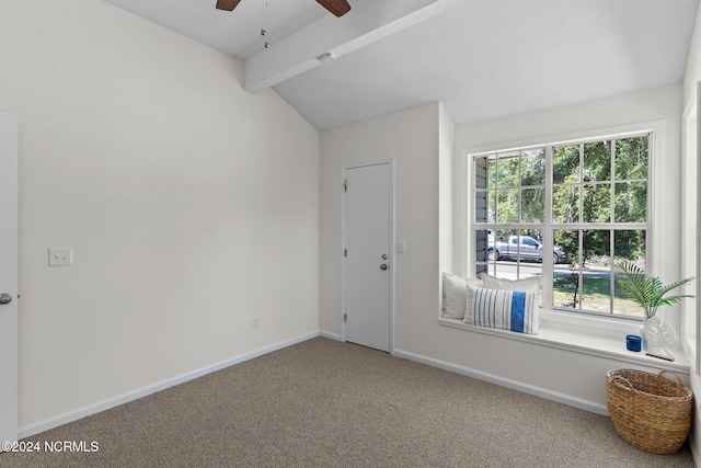 spare room with plenty of natural light, ceiling fan, vaulted ceiling with beams, and carpet flooring