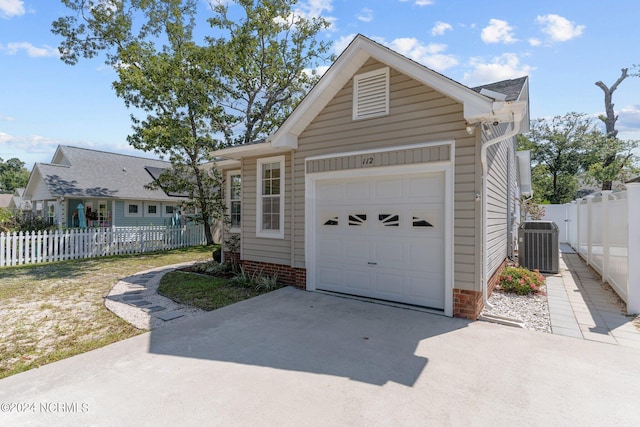 view of front of house with a garage and central air condition unit