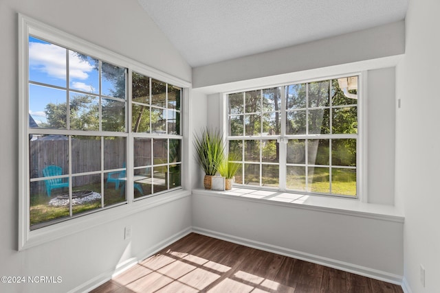 interior space featuring hardwood / wood-style floors, vaulted ceiling, plenty of natural light, and a textured ceiling