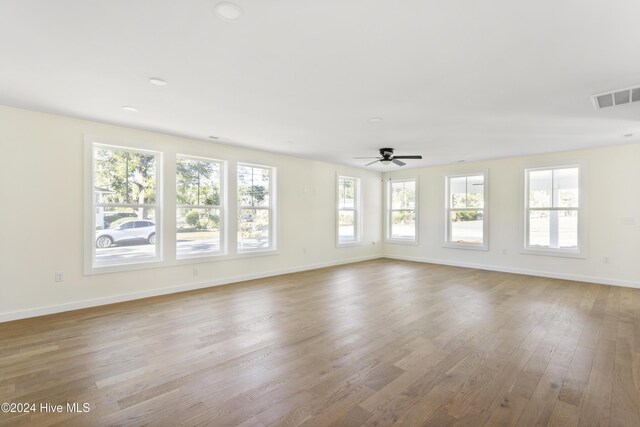 unfurnished living room featuring light hardwood / wood-style floors, ceiling fan, and sink