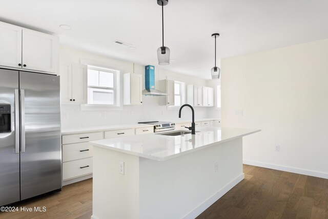 kitchen with white cabinets, light hardwood / wood-style floors, sink, and an island with sink