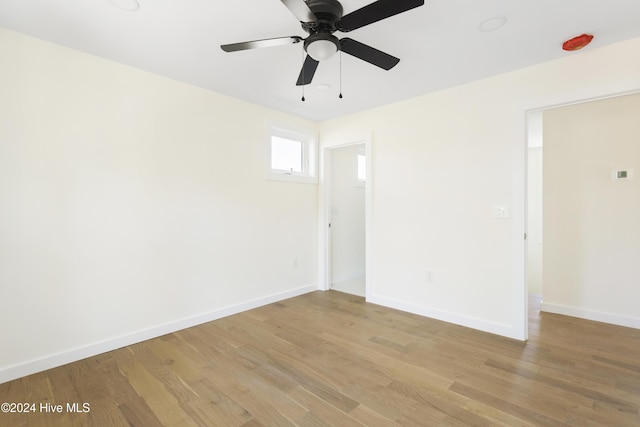 unfurnished bedroom with connected bathroom, ceiling fan, and light hardwood / wood-style flooring