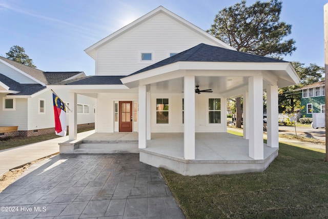 rear view of house with a lawn, covered porch, and ceiling fan