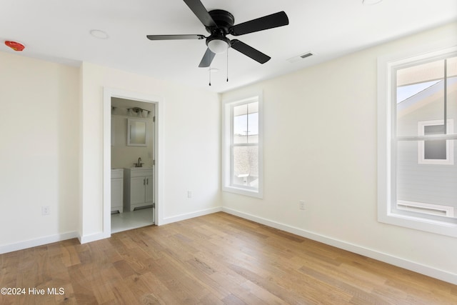 unfurnished bedroom with connected bathroom, sink, ceiling fan, and light hardwood / wood-style flooring