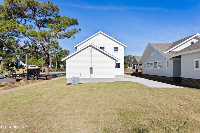 rear view of house with a yard and cooling unit