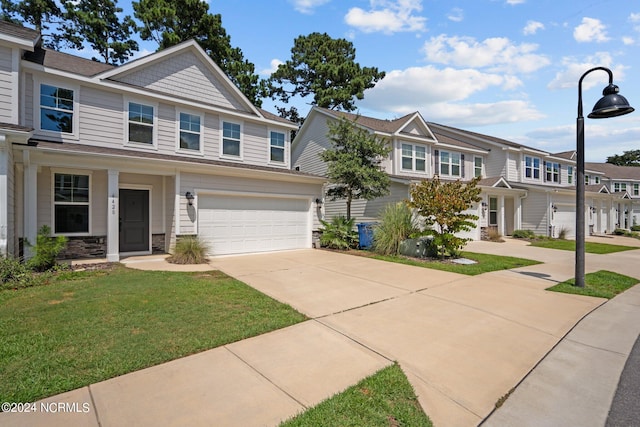 view of property featuring a garage and a front lawn