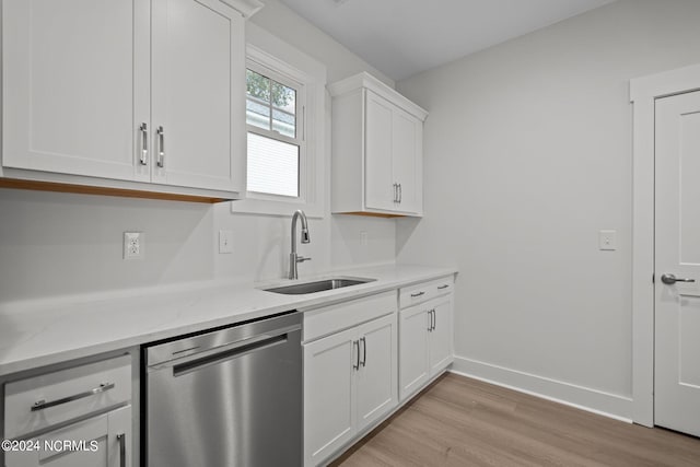 kitchen featuring light hardwood / wood-style floors, white cabinetry, light stone counters, dishwasher, and sink