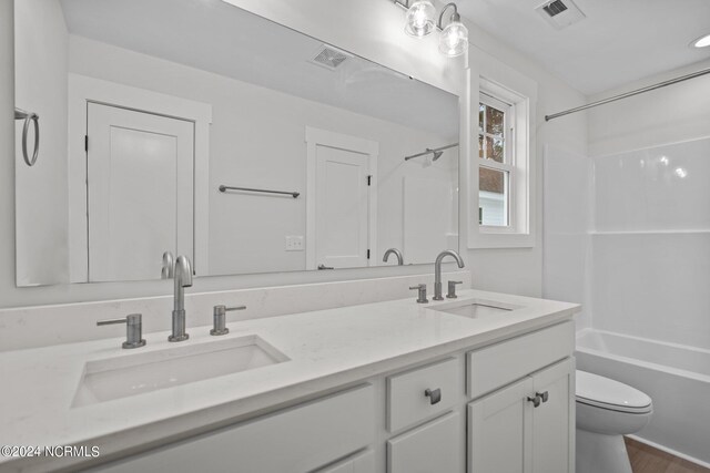 full bathroom with  shower combination, hardwood / wood-style flooring, vanity, and toilet